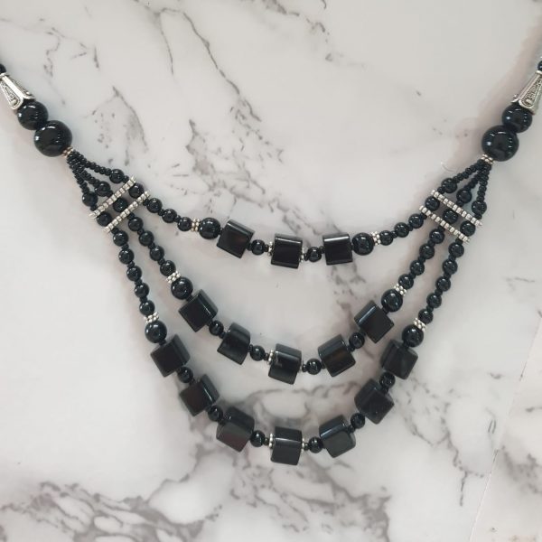 Charismatic Cubes - Handmade Kalasha Necklace The Charismatic Cubes necklace is the perfect blend of modern and antique. This triple-layered handmade Kalasha necklace comes in two colours & designs and is just what you need to look dashing on a night out! Colour options: Black and Blue