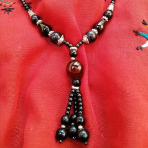 Pearly Black - Handmade Kalasha Necklace Make a striking fashion statement flaunting this bold & glamorous handmade Kalasha necklace. An intermediate between black and brown, it is lightweight and easy to wear, perfect for your daily fashion needs! Stone: Aqeeq Colour: Shades of brown & black