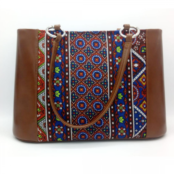 Block Printed Heaven - Pure Leather Handbag with traditional touches A classical handbag with a traditional twist. Featuring a simple & popular silhouette, this bag is perfect to carry everything you need to have with you when on the go! Made out of 100% pure buffalo leather with Sindhi block-printed fabric incorporated to make it stand out and give it a desi touch!