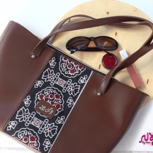 Brown Motif - Faux Leather Tote Bag A classical handbag with a traditional twist. Featuring a simple & popular silhouette, this bag is perfect to carry everything you need to have with you when on the go! Made out of faux leather with traditional printed fabric incorporated to make it stand out and give it a desi touch!