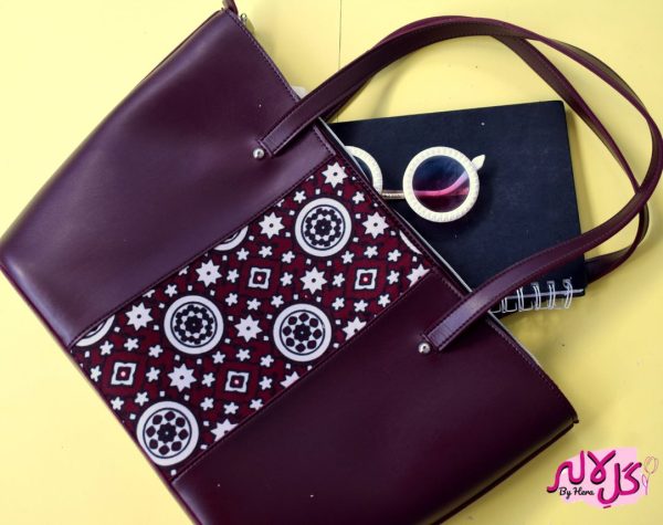 Burgundy Vibes - Faux Leather Tote Bag A classical handbag with a traditional twist. Featuring a simple & popular silhouette, this bag is perfect to carry everything you need to have with you when on the go! Made out of faux leather with traditional printed fabric incorporated to make it stand out and give it a desi touch!