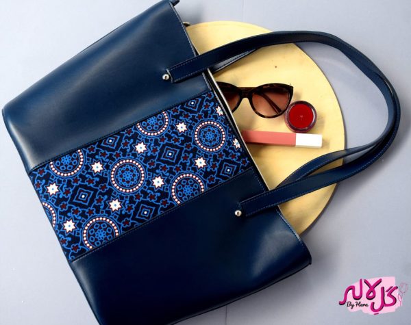 Blue Royalty - Faux Leather Tote Bag A classical handbag with a traditional twist. Featuring a simple & popular silhouette, this bag is perfect to carry everything you need to have with you when on the go! Made out of faux leather with traditional printed fabric incorporated to make it stand out and give it a desi touch!