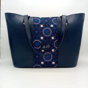 Blue Royalty - Faux Leather Tote Bag A classical handbag with a traditional twist. Featuring a simple & popular silhouette, this bag is perfect to carry everything you need to have with you when on the go! Made out of faux leather with traditional printed fabric incorporated to make it stand out and give it a desi touch!