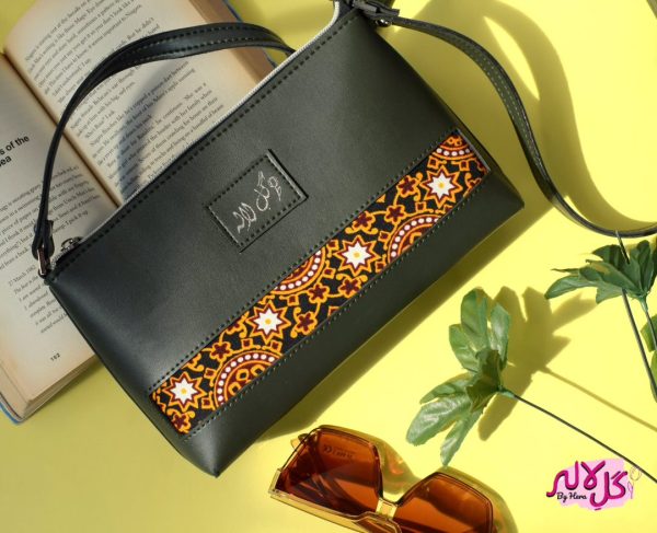 Grassy Green - Faux Leather Cross-Body Bag A classical cross-body bag with a traditional twist. Featuring a simple & popular silhouette, this bag is perfect to carry everything you need to have with you when on the go! Made out of faux leather with traditional printed fabric incorporated to make it stand out and give it a desi touch!