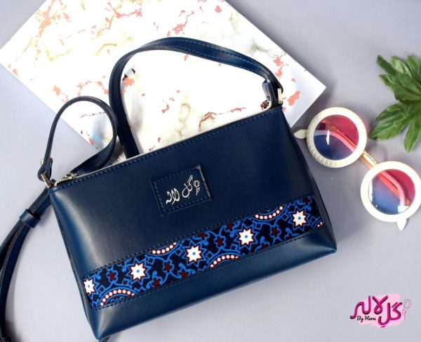 Blue Bliss - Faux Leather Cross-Body Bag A classical cross-body bag with a traditional twist. Featuring a simple & popular silhouette, this bag is perfect to carry everything you need to have with you when on the go! Made out of faux leather with traditional printed fabric incorporated to make it stand out and give it a desi touch!