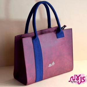 The Glam Bag - Maroon Spacious, glamorous yet lightweight, The Glam Bag is the perfect bag to carry to every munch, brunch & lunch. Both a classic and a fashionable statement piece, The Glam Bag embodies the essence of effortless chic. The tasteful addition of the blue strap gives it a denim effect! It can be carried on the shoulder or held in the hand. For easy accessibility, it is equipped with a detachable long strap. Locally made in Pakistan