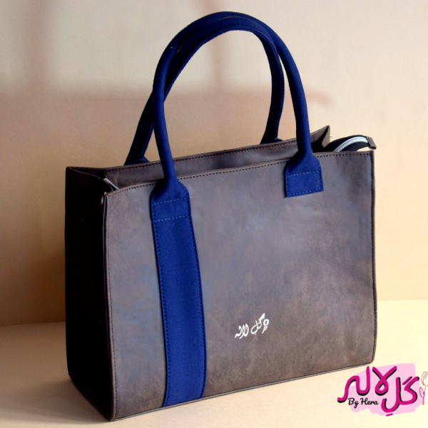 The Glam Bag - Brown Spacious, glamorous yet lightweight, The Glam Bag is the perfect bag to carry to every munch, brunch & lunch. Both a classic and a fashionable statement piece, The Glam Bag embodies the essence of effortless chic. The tasteful addition of the blue strap gives it a denim effect! It can be carried on the shoulder or held in the hand. For easy accessibility, it is equipped with a detachable long strap. Locally made in Pakistan