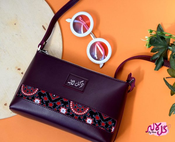 Marooned - Faux Leather Cross-Body Bag A classical cross-body bag with a traditional twist. Featuring a simple & popular silhouette, this bag is perfect to carry everything you need to have with you when on the go! Made out of faux leather with traditional printed fabric incorporated to make it stand out and give it a desi touch!