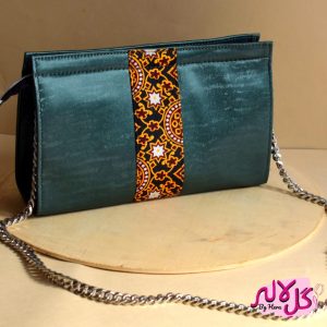 Green Gloss - Faux Leather Chain Bag A shiny beautiful chained bag with a traditional twist. Featuring a simple & popular silhouette, this bag is perfect to carry everything you need to have with you when on the go! Made out of faux leather with traditional printed fabric incorporated to make it stand out and give it a desi touch!