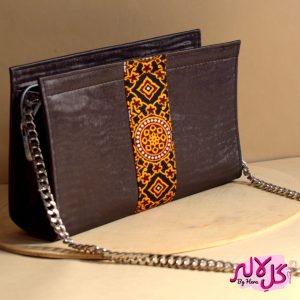 Polished Brown - Faux Leather Chain Bag A shiny beautiful chained bag with a traditional twist. Featuring a simple & popular silhouette, this bag is perfect to carry everything you need to have with you when on the go! Made out of faux leather with traditional printed fabric incorporated to make it stand out and give it a desi touch!